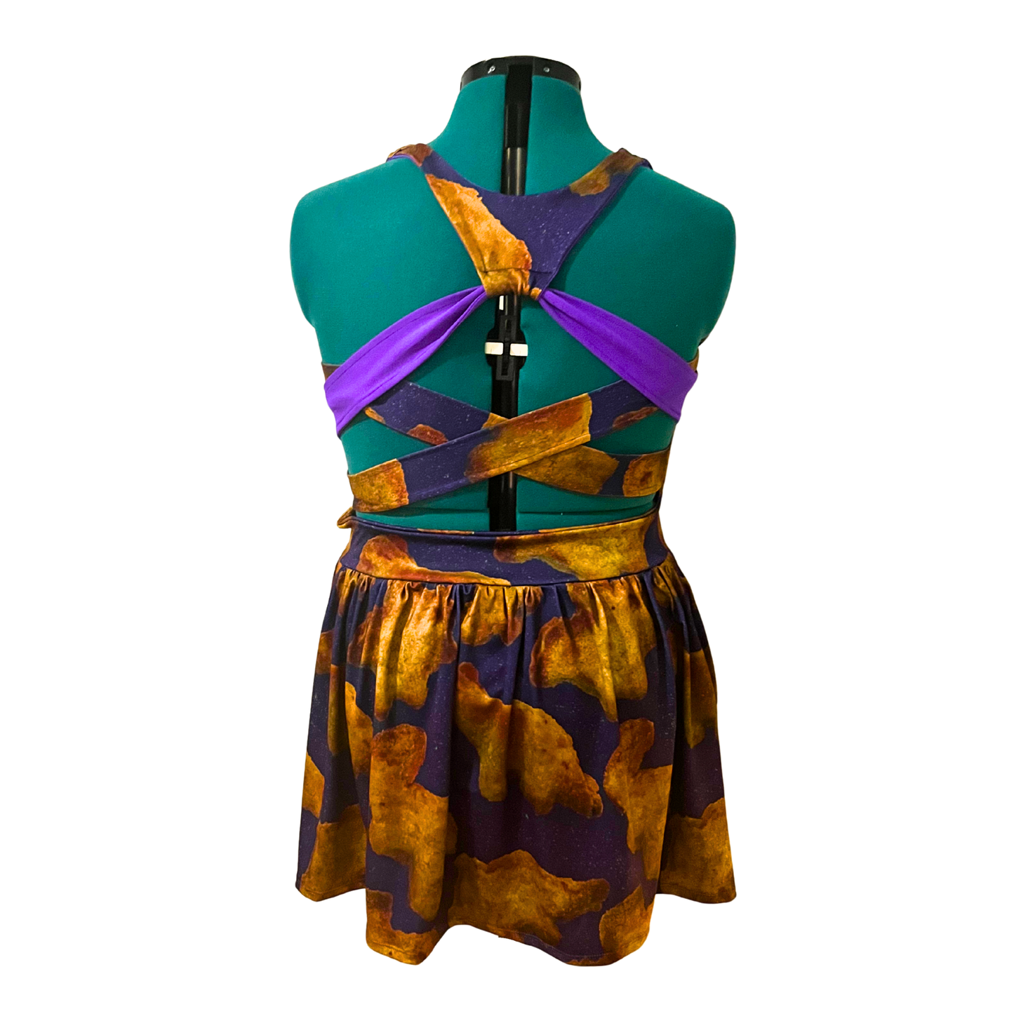 back of purple dress with Dino nuggets print on a mannequin in front of a white background