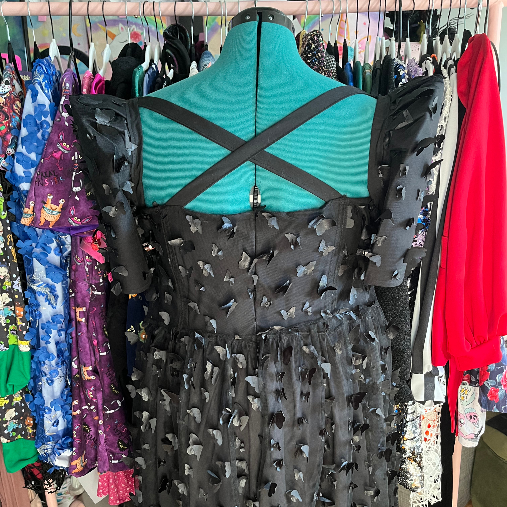 Mannequin wearing a black dress in a clothing store.