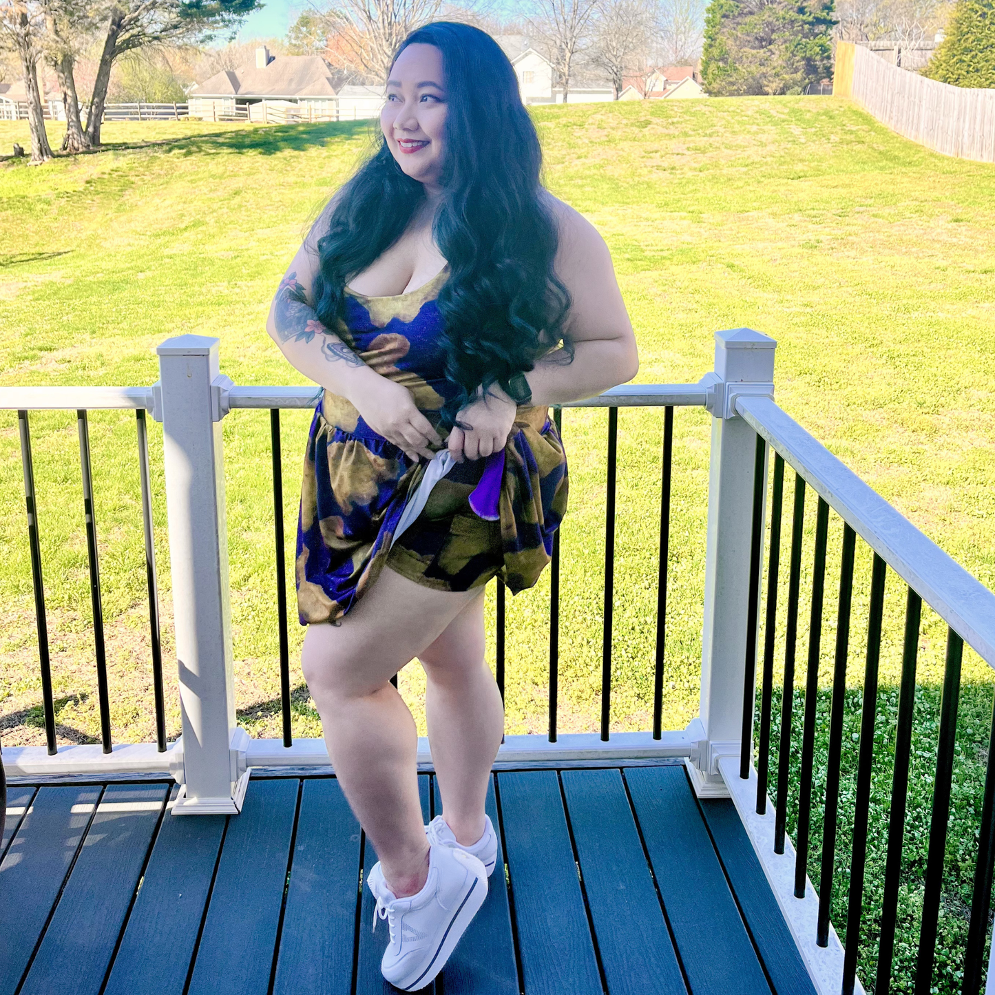 woman standing on a deck wearing a dress and showing the attached shorts