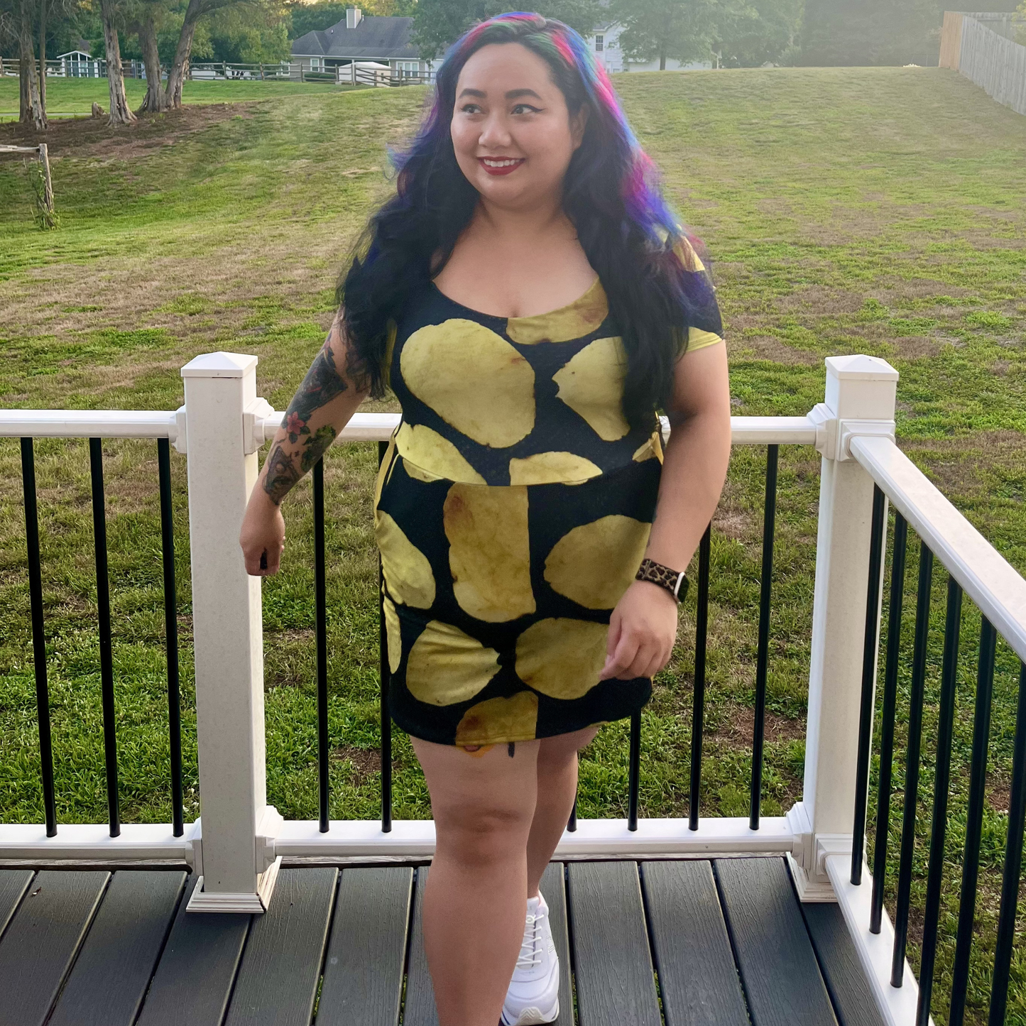 woman standing on a deck in front of a lawn wearing a potato chip print dress