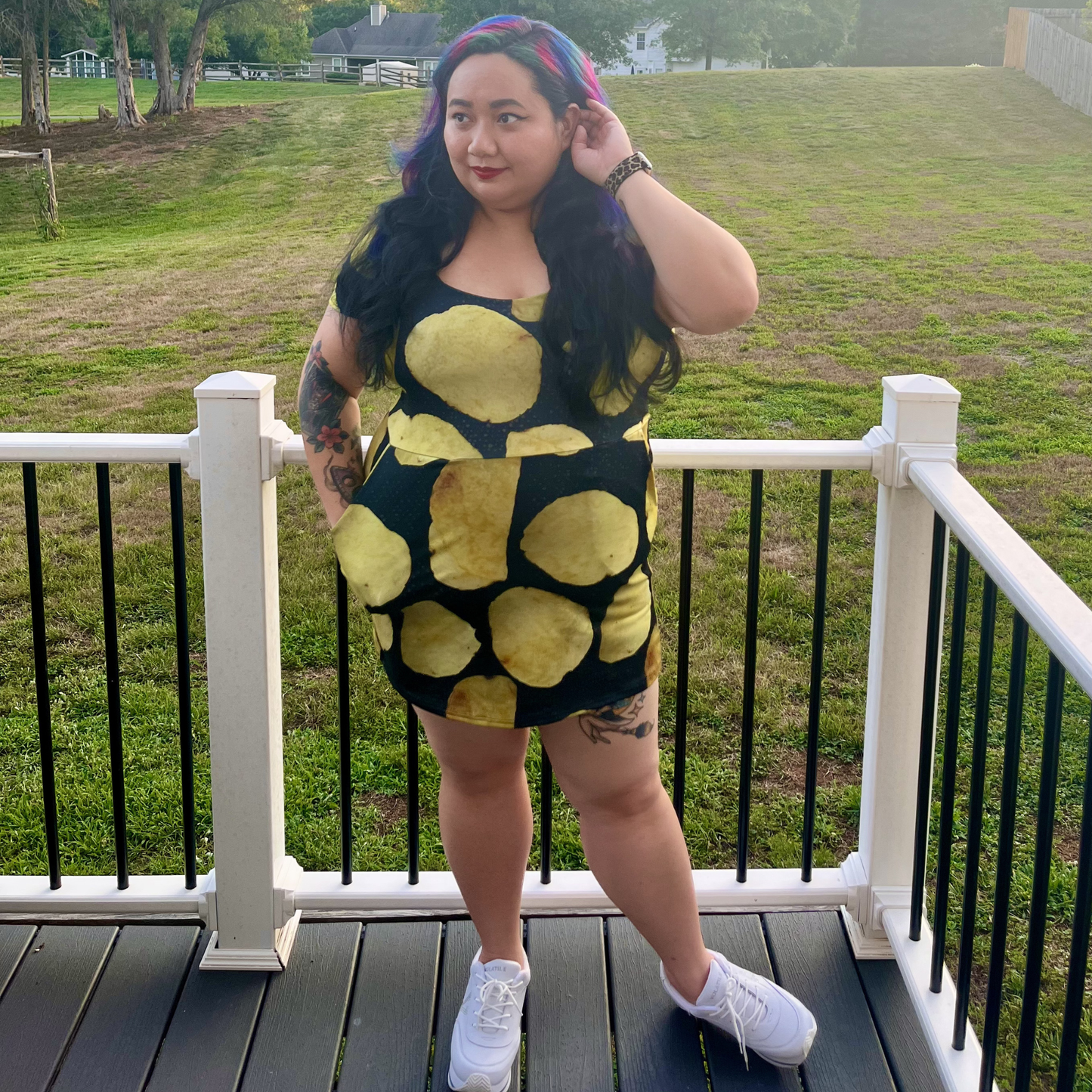 woman standing on a deck in front of a lawn wearing a potato chip print dress