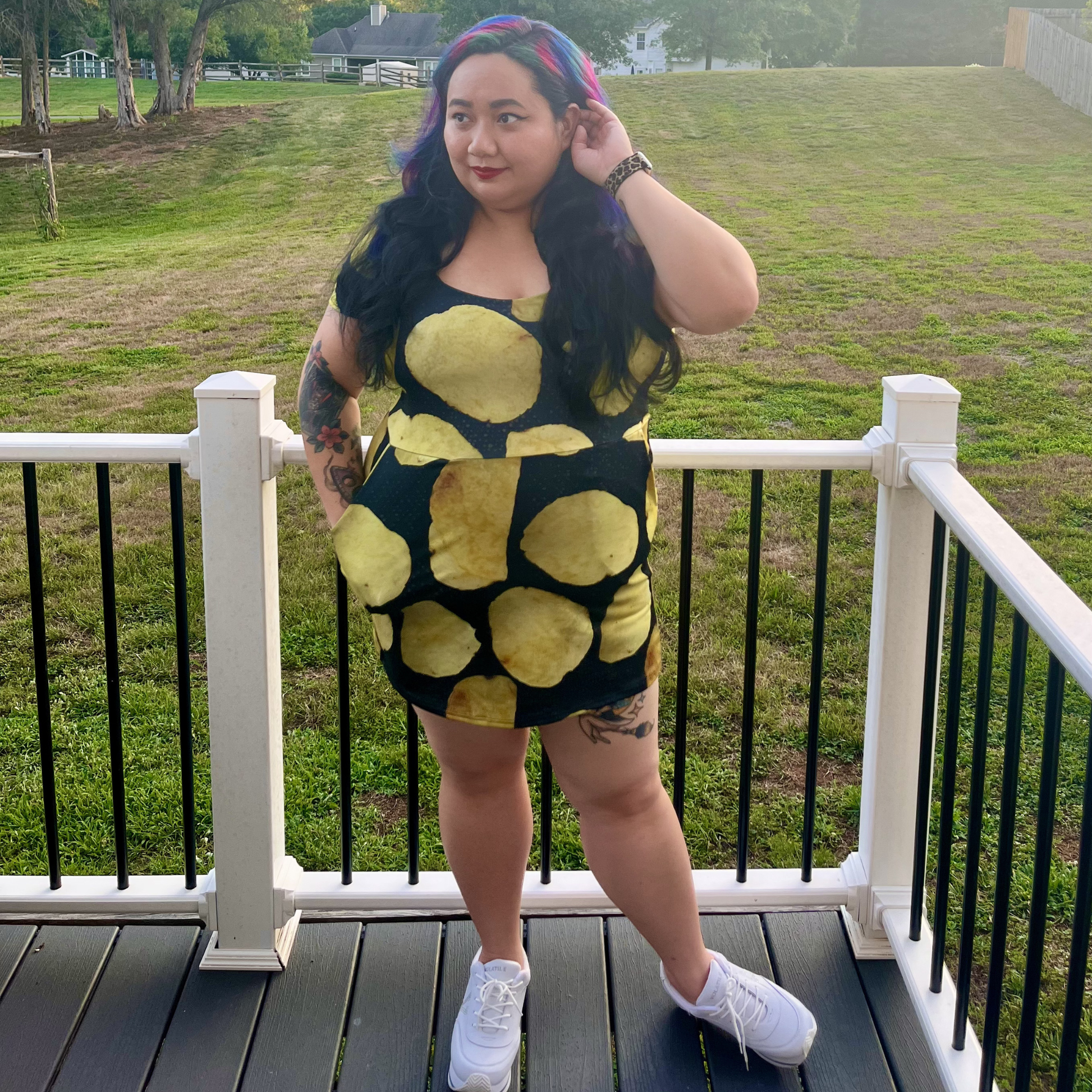 woman standing on a deck in front of a lawn wearing a potato chip print dress
