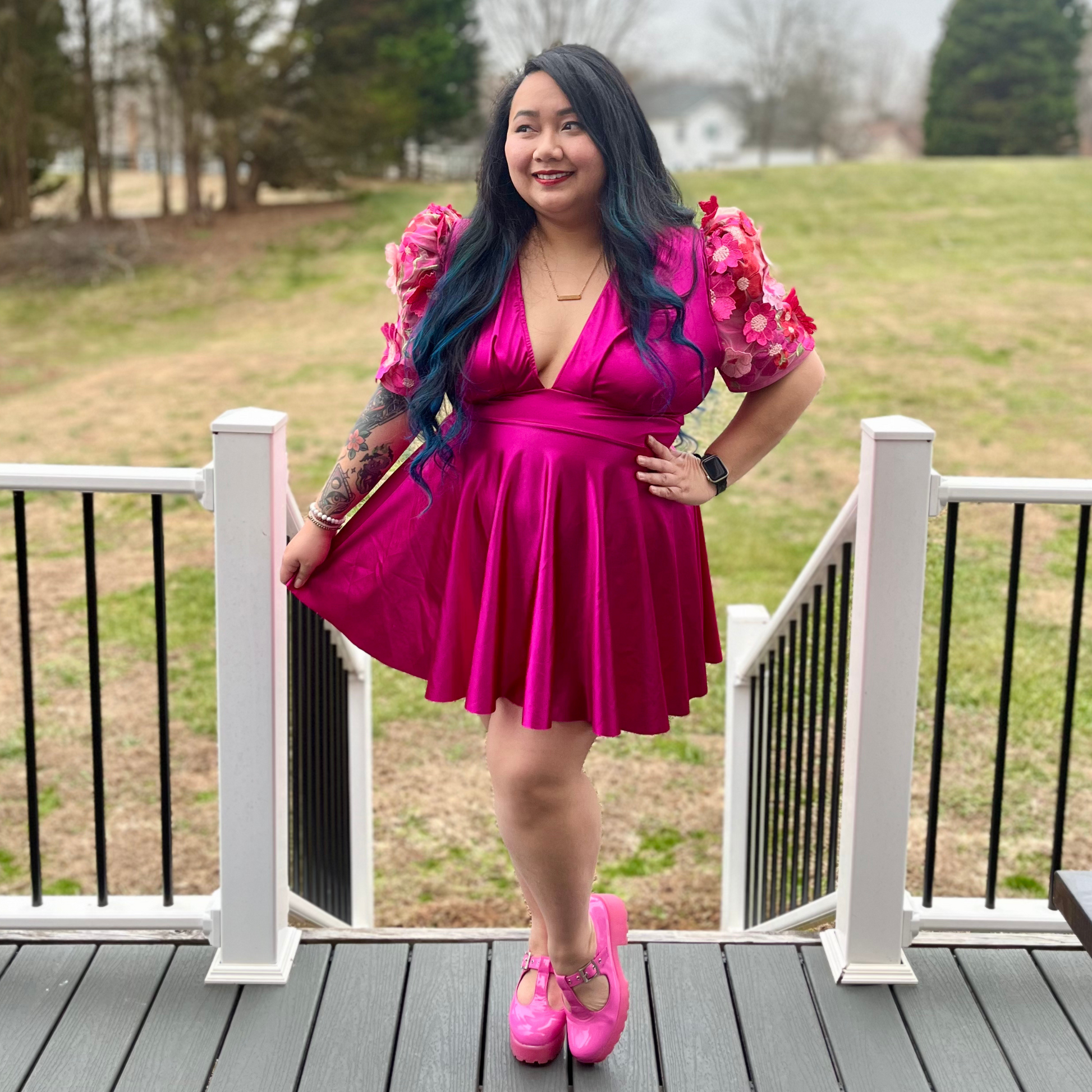 Woman wearing a magenta dress standing on a deck