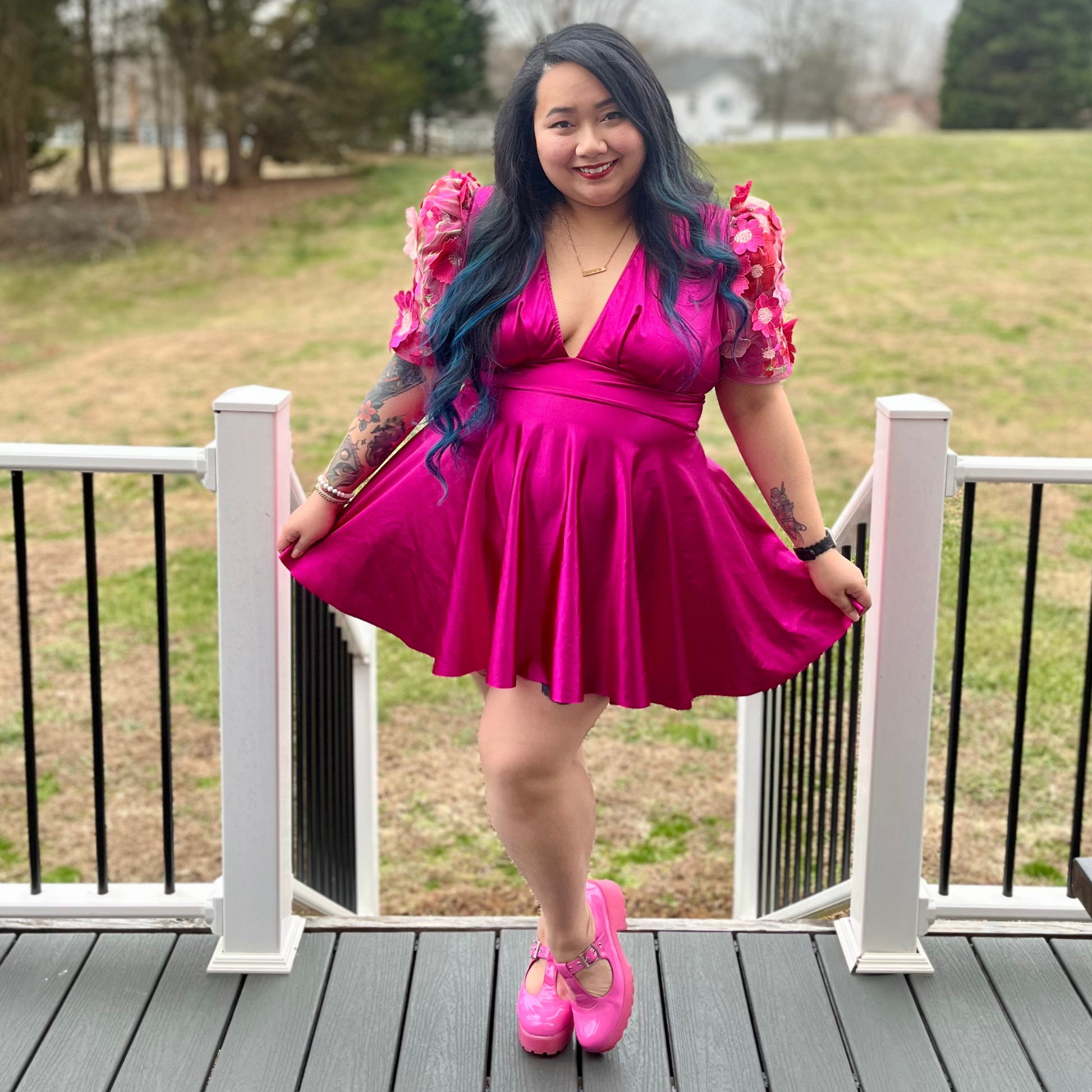 Woman wearing a magenta dress standing on a deck